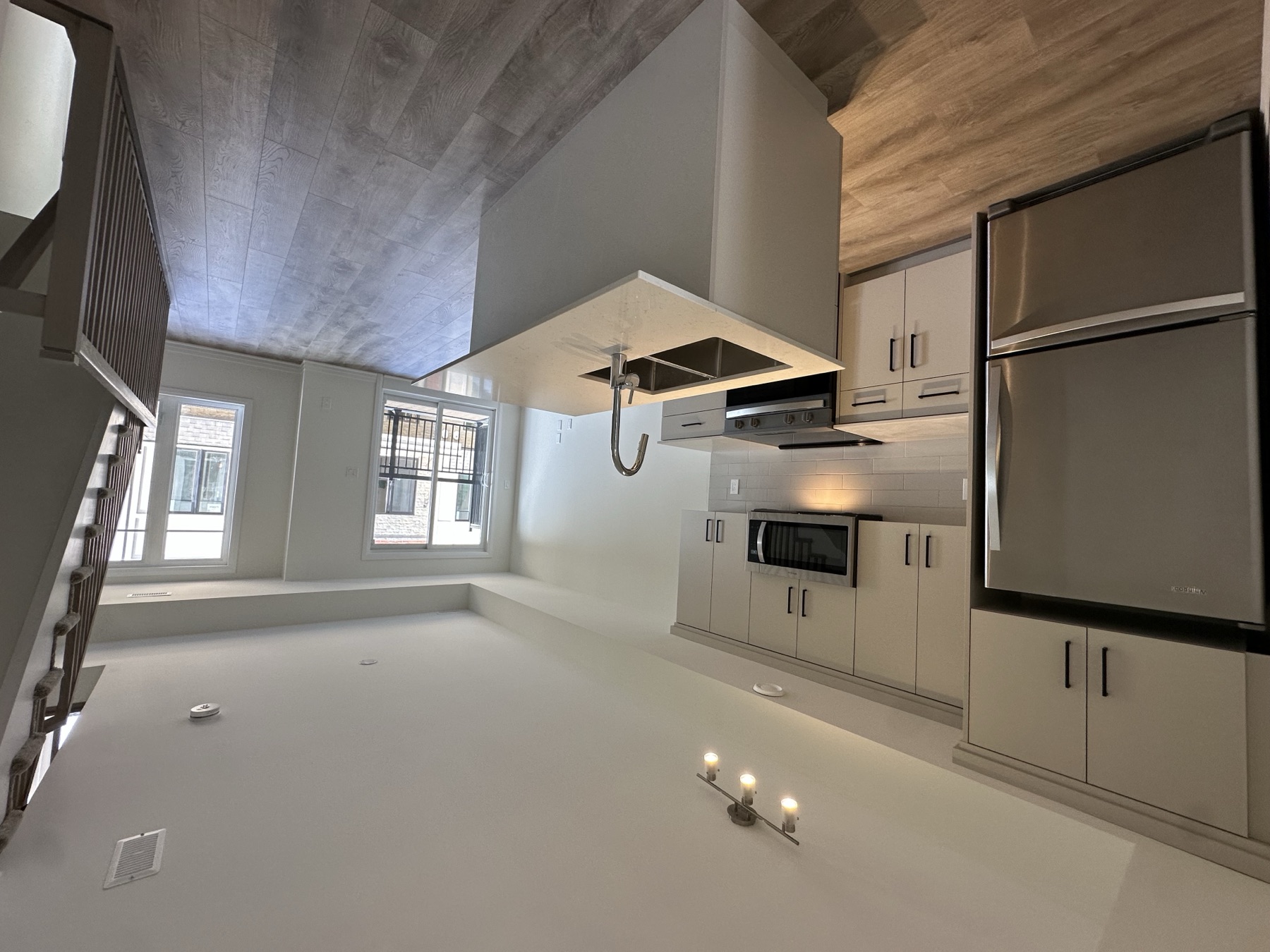 Finished kitchen with an island, stainless steel appliances and an adjoining living area